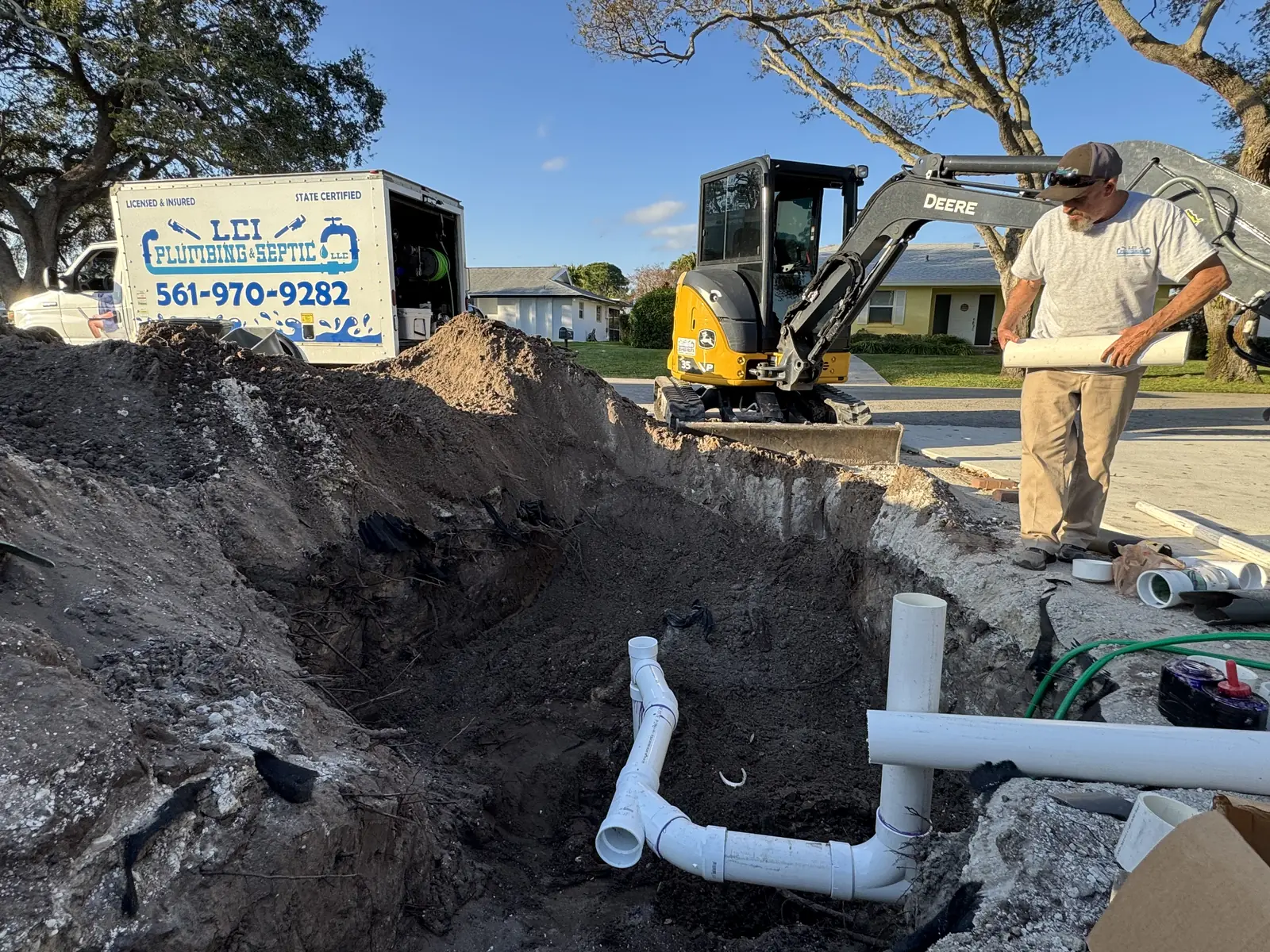 Crew and excavator on a sewer line tie-in