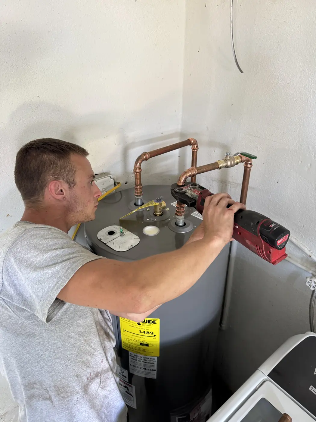Tech installing a new electric water heater